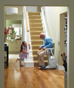 Image of a man sitting on a stair lift with young girl. Arrow Lift