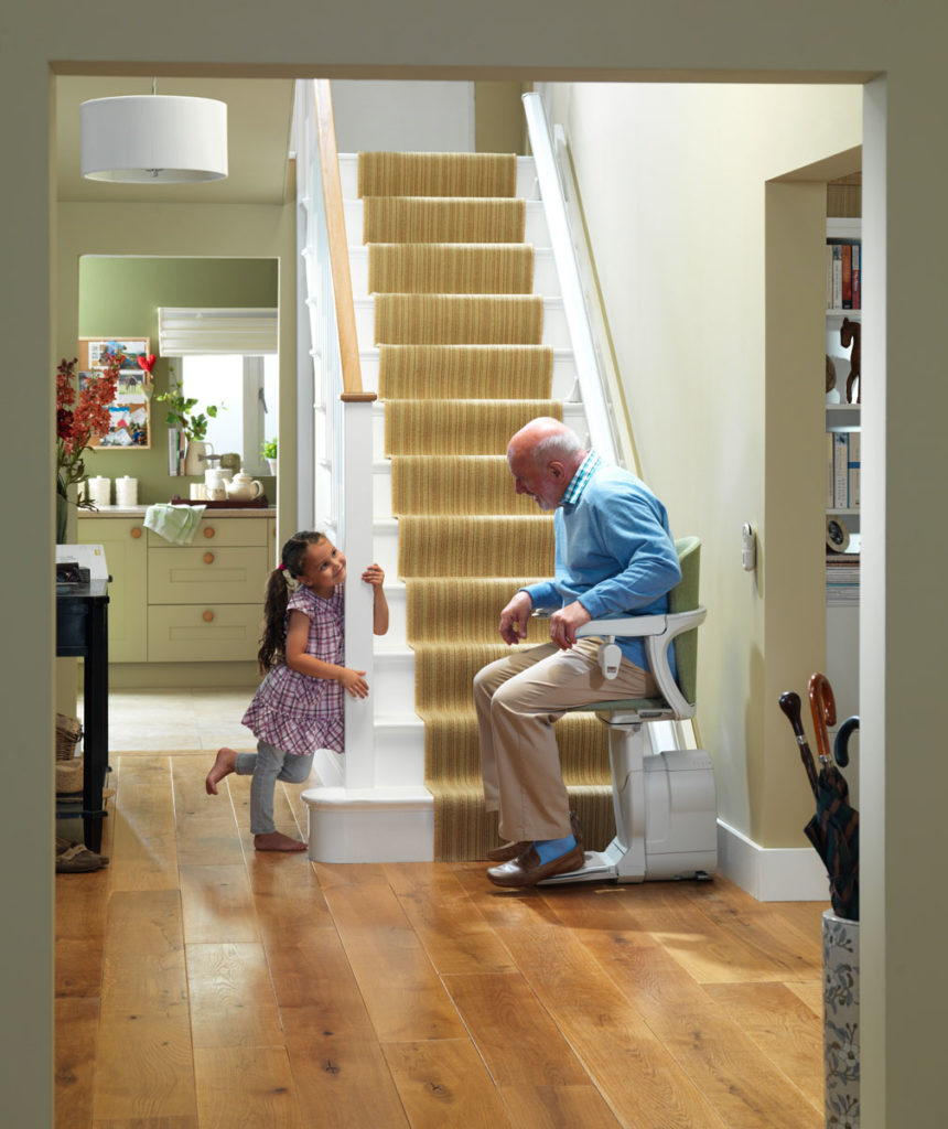 Image of a man sitting on a stair lift with young girl. Arrow Lift