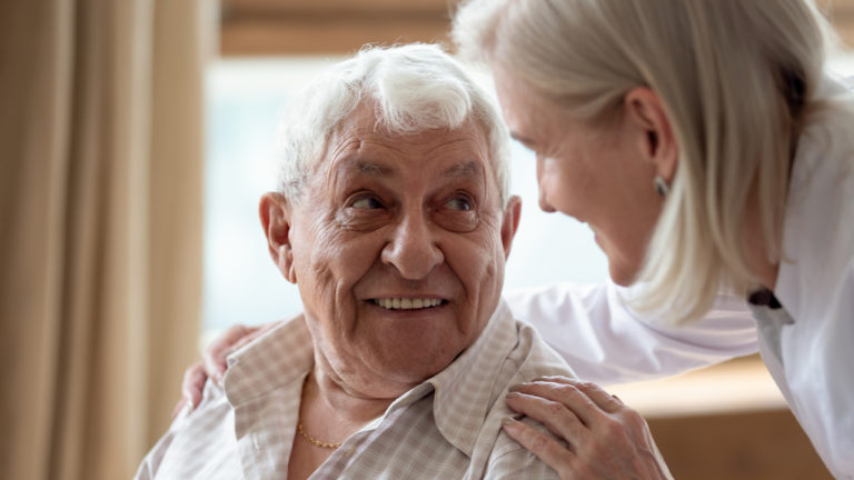 Elderly couple smiling at each other