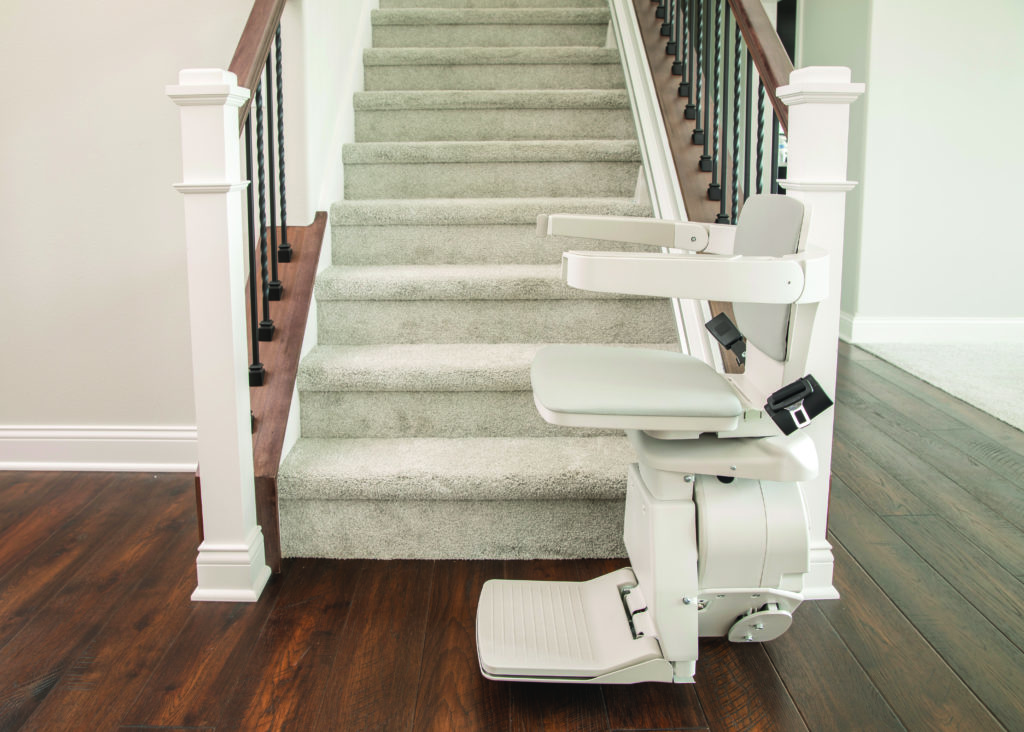 Image of a stair lift at the base of a staircase, these lifts are sometimes called stair elevators | Arrow Lift 