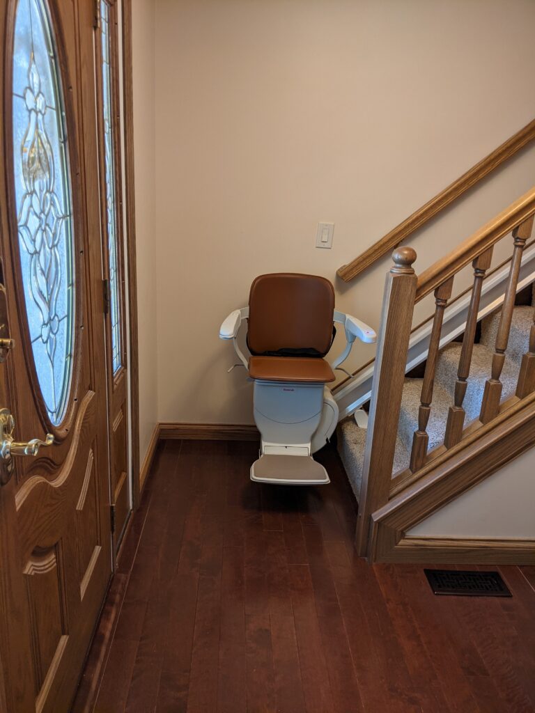 Straight stair lift with chair at bottom landing