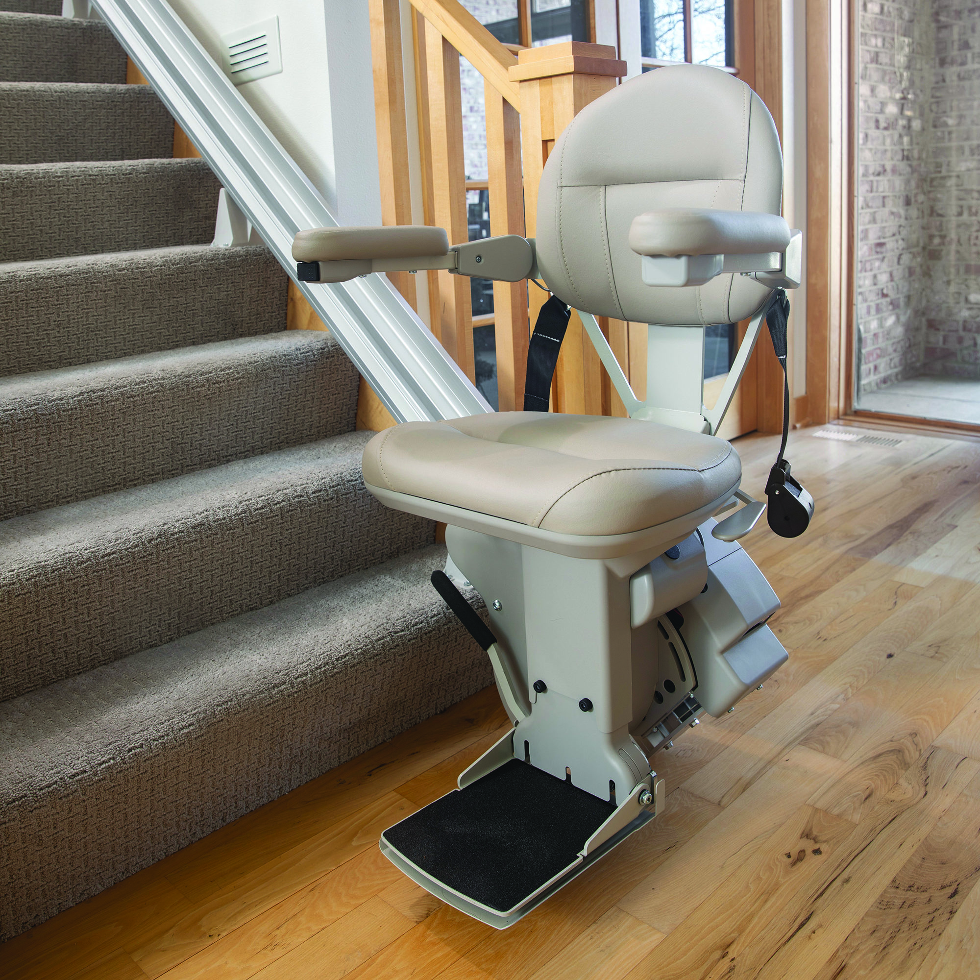 Bruni Elite Stair Lift at base of stairs with seat and arms down. Arrow Lift
