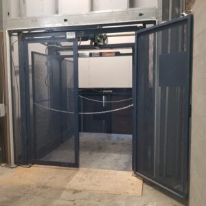 Black metal material lift with door open. Arrow Lift.