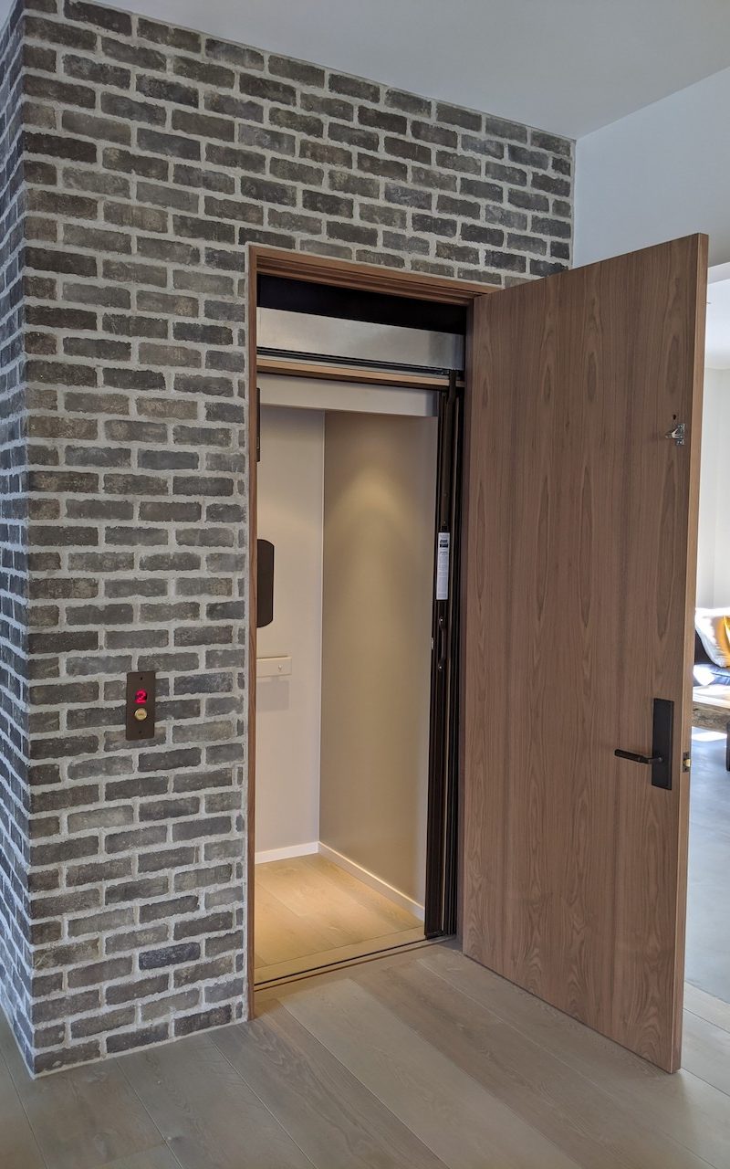 Home Elevator with door open. Interior panels are painted to match home interior. Arrow Lift.