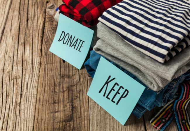Image of sorted clothing into "keep" and "donate" piles. 