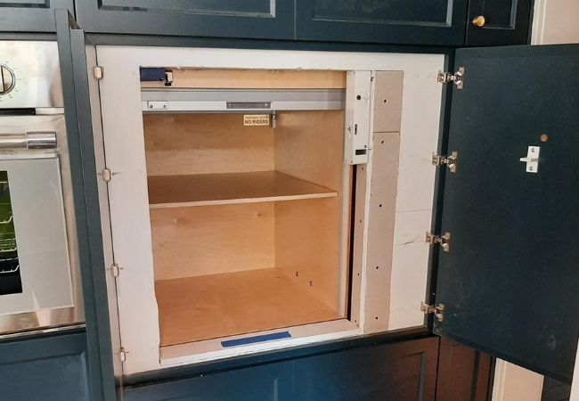 Image of a mostly completed Arrow Lift dumbwaiter installation with the door open. 
