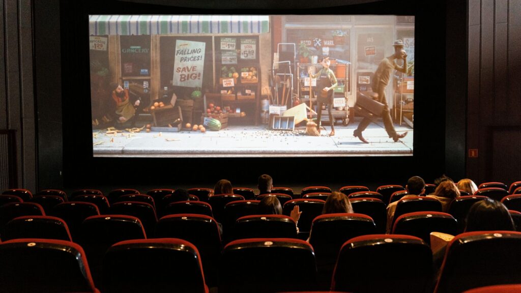 Image from seats of a Movie theater with an unknown cartoon playing on the screen. 