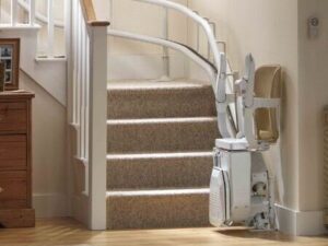 curved stair lift with chair at bottom landing in folded position
