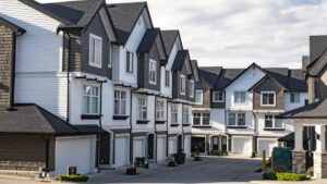 Several rows of three-story townhomes line a neighborhood street.