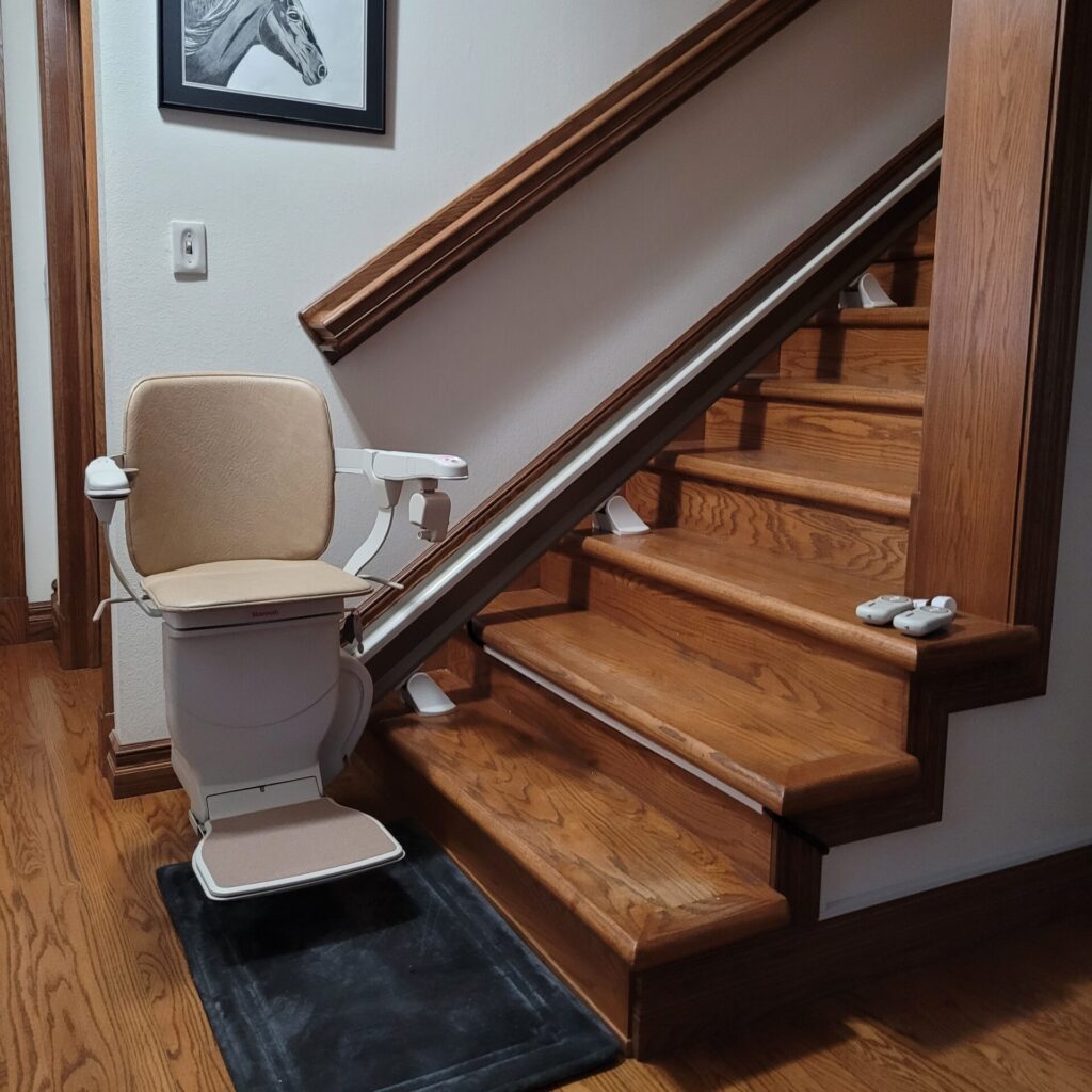 Image of a stair lift unfolded at the base of a staircase