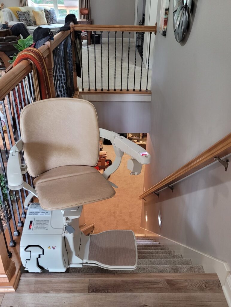 stair lift at top of stairs with chair turned for rider to sit down