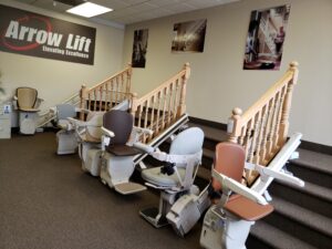 Multiple stair lift models at the base of the stairs in the Bloomington Arrow Lift Showroom