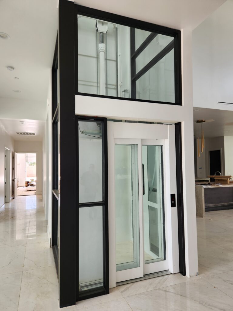 Glass home elevator with black and white trim