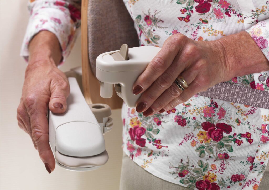 A woman attaching the seatbelt while seated on her stair lift chair