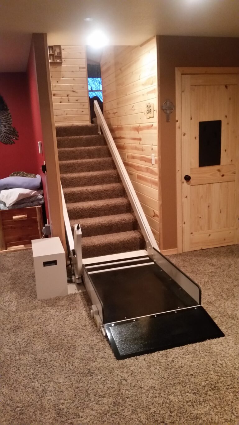 An inclined platform lift installed at the base of a staircase.