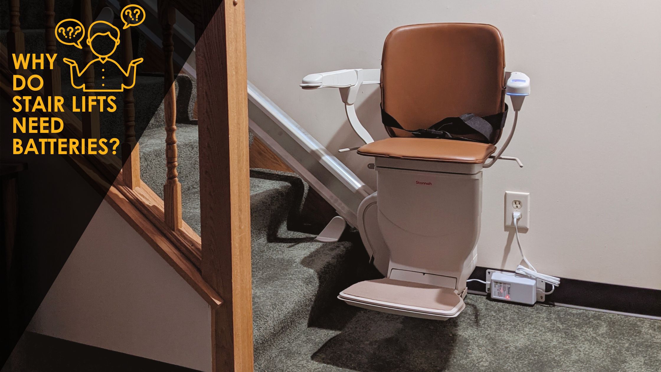 A stair lift is plugged into an outlet at the base of carpeted stairs.