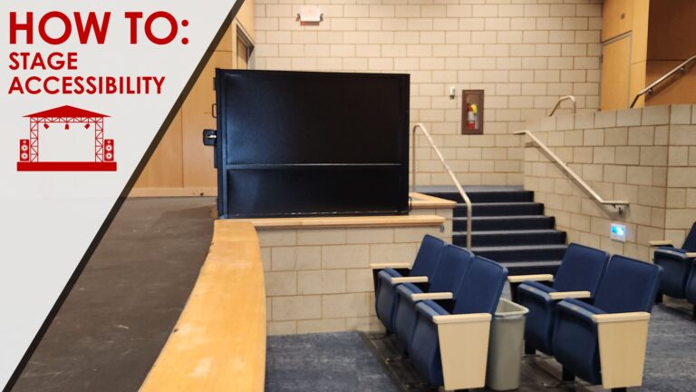 Wheelchair lift providing stage access in an auditorium with blue theater seating, showcasing stage accessibility solutions for performance venues.