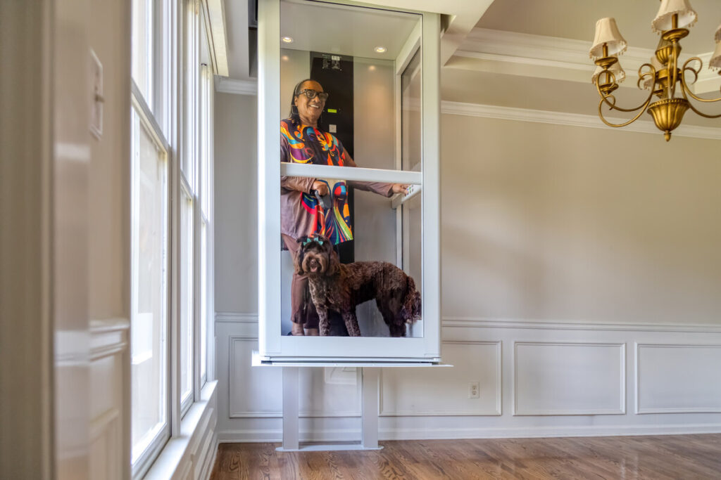 Woman and her dog riding in a shaftless elevator