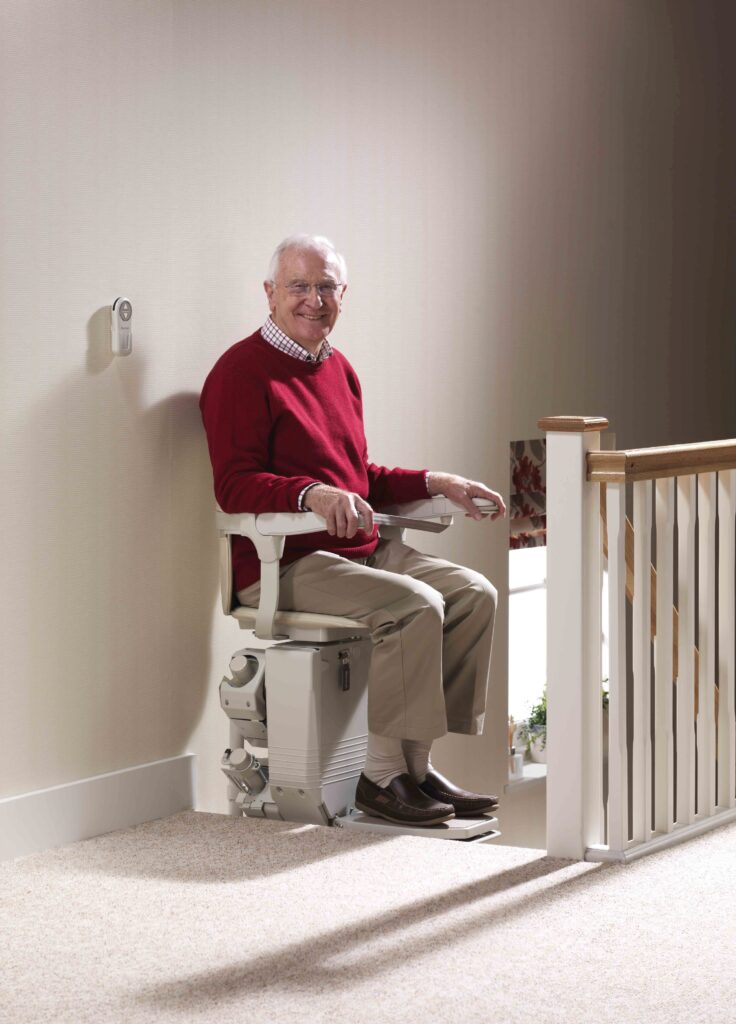 man sitting in a reconditioned stair lift