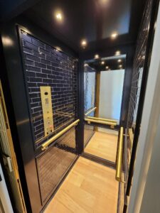 traditional home elevator with custom glass tiles and mirror and gold accents